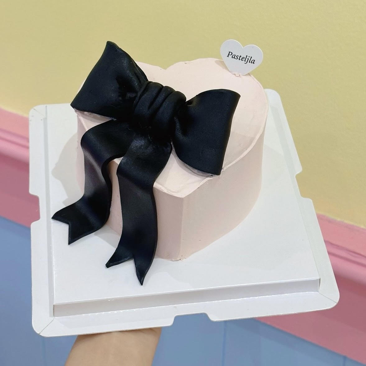 Heart shape soft pink with black bow cake